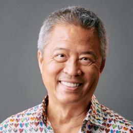 Asian man with graying hair, smiling